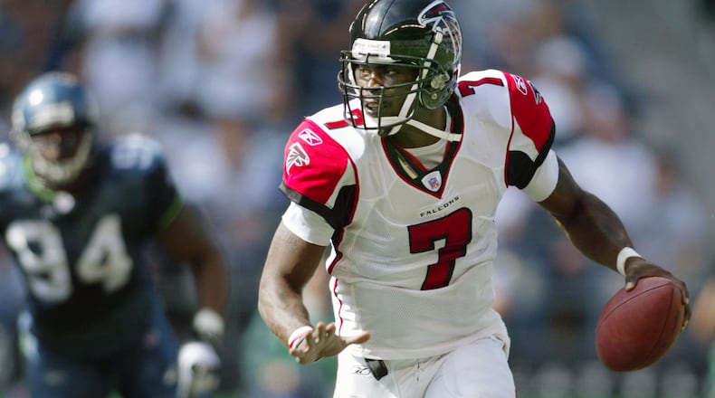 Falcons quarterback Michael Vick looks for a receiver while scrambling under pressure from Seattle Seahawks’ Bryce Fisher (94) during the second quarter in Seattle Sunday, Sept. 18, 2005. (AP Photo/John Froschauer)