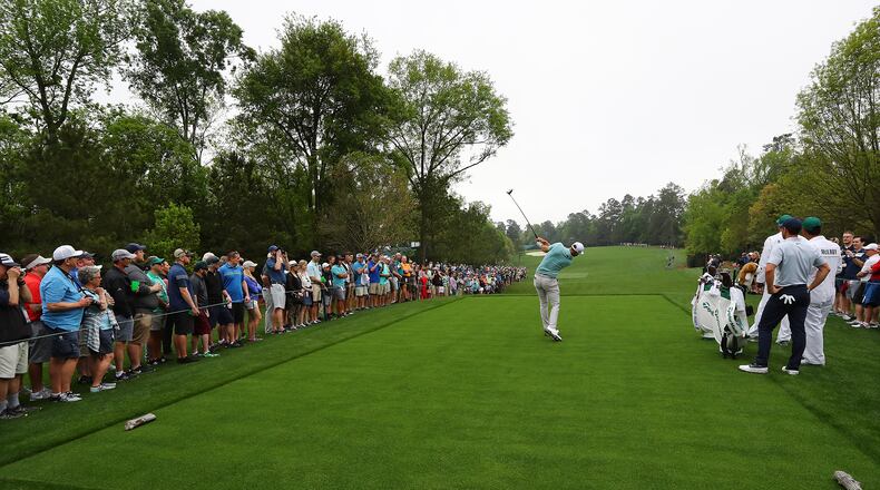 Dustin Johnson tries out the new tee box at the fifth hole at Augusta National. Honestly, there is a green out there, somewhere. (Curtis Compton/ccompton@ajc.com)