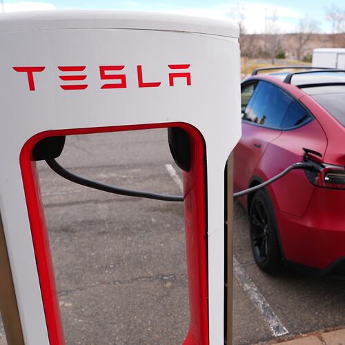 A motorist sits in a Tesla Model 3 at a Tesla charging station Friday, March 13, 2026, in Lakewood, Colo., in Denver. (David Zalubowski/AP)