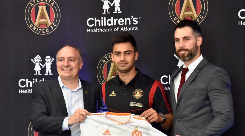 Atlanta United's newest signing, Pity Martinez (center), poses with team president Darren Eales (left) and Carlos Bocanegra (right) on Friday at the team's training ground in Marietta. (Hyosub Shin / AJC)