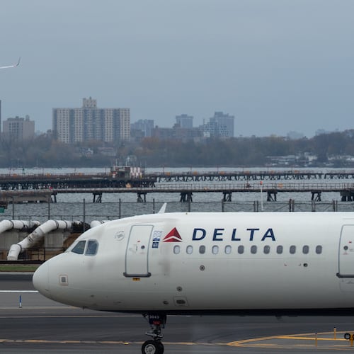 An American Airlines flight lands as a Delta Air Lines plane taxis at LaGuardia Airport (LGA) in the Queens borough of New York, Sunday, Nov. 9, 2025. (AP Photo/Adam Gray)