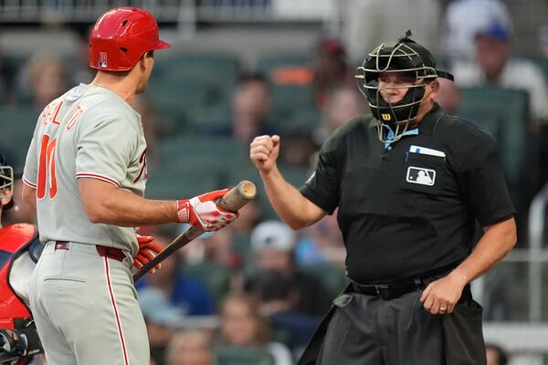 Philadelphia Phillies catcher J.T. Realmuto (10) speaks with the umpire after striking out against the Atlanta Braves in the second inning of a baseball game, Thursday, April 10, 2025, in Atlanta. (AP Photo/Mike Stewart)
