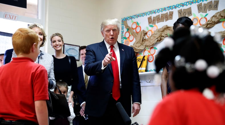 President Donald Trump talks to children in Jane Jones fourth grade class during a tour of Saint Andrew Catholic School, Friday, March 3, 2017, in Orlando, Fla. At left is Trump's daughter Ivanka Trump. (AP Photo/Alex Brandon)
