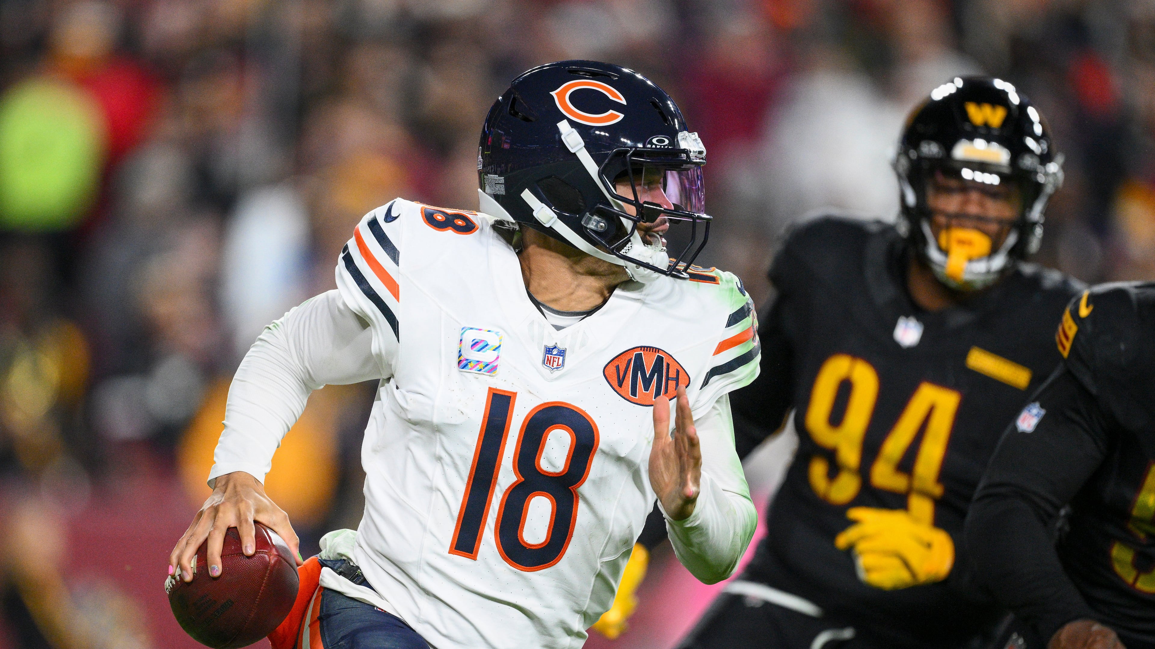 Chicago Bears quarterback Caleb Williams (18) runs away from Washington Commanders nose tackle Daron Payne (94) during the second half of an NFL football game Monday, Oct. 13, 2025, in Landover, Md. (AP Photo/Nick Wass)