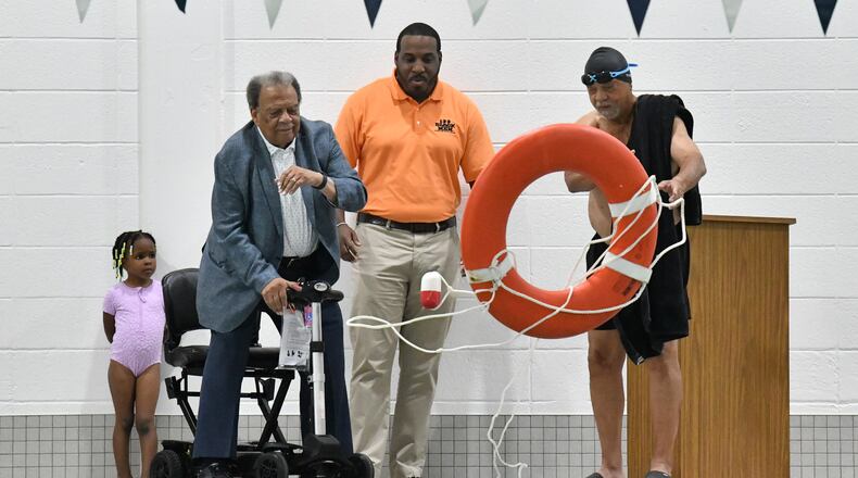 Ambassador Andrew Young (left) and his brother Walter Young toss a lifeguard ring during a ribbon cutting ceremony to inaugurate the new pool at Andrew and Walter Young Family YMCA, Wednesday, July 5, 2023, in Atlanta. (Hyosub Shin / Hyosub.Shin@ajc.com)