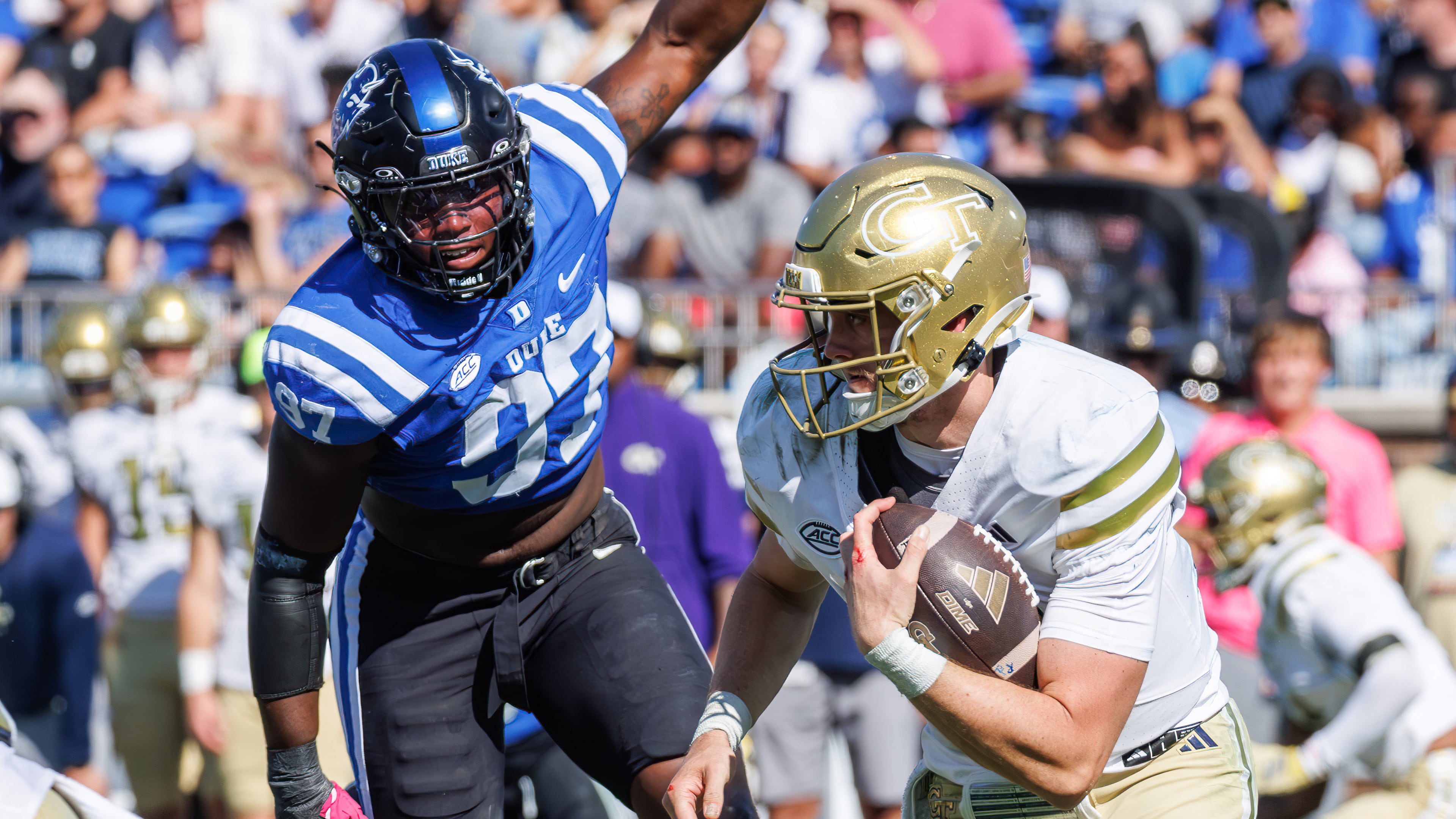 Georgia Tech's Haynes King, right, carries the ball ahead of Duke's Wesley Williams (97) during the second half of an NCAA college football game in Durham, N.C., Saturday, Oct. 18, 2025. (AP Photo/Ben McKeown)