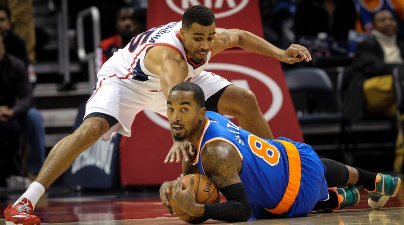 New York Knicks guard J.R. Smith (8) tries to keep a loose ball from Atlanta Hawks guard Thabo Sefolosha, of Switzerland, during the first half of an NBA basketball game, Saturday, Nov. 8, 2014, in Atlanta. (AP Photo/John Amis)