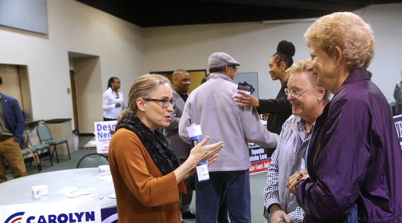 Carolyn Bourdeaux, left, a 7th Congressional District Democratic candidate, greets voters Deborah Teitsman and Carolyn Sudberry at a United Peachtree Corners Civic Association event on Monday in Peachtree Corners. Curtis Compton/ccompton@ajc.com