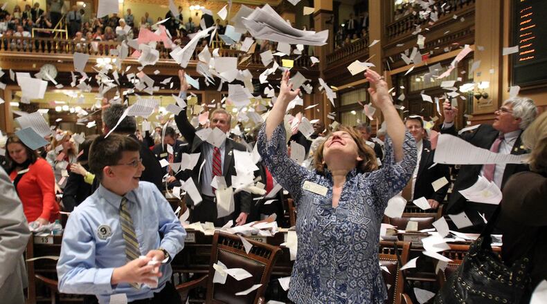 March 29, 2012 ATLANTA: Rep. Donna Sheldon, R-Dacula, center, throws paper into the air next to Thomas Allison after the House Majority Leader, Rep. Larry O'Neal yelled, "Sine Die, " to end the 2012 Legislative Session at the stroke of midnight on Legislative Day 40 at the Capitol Thursday afternoon in Atlanta, Ga., March 29, 2012. This was the finale of a three-month assignment to photograph the 2012 Legislative Session. I've heard a lot about, "Sine Die, " and enjoyed covering the event. I was focused on the Speaker of the House and waited for someone to react after throwing paper in the air. I saw Rep. Sheldon toss paper in the air and quickly turned to get off a few frames. I was happy to get a few before she put her arms down. Jason Getz jgetz@ajc.com