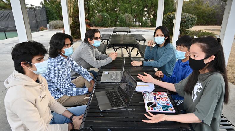 The students behind Ingenify, a free online tutoring website, (clockwise from left) co-founders Bedansh Pandey, 16, and Paul Philip, 17, team member Ali Addis, 16, co-founder Benson Zhang, 17, and team members Grant Peng, 14, and Grace Peng, 16, talk at a neighborhood park where they often meet in Suwanee on Wednesday, Feb. 10, 2021. The fourth co-founder, Jatong Su, 17, is not pictured. (Hyosub Shin / Hyosub.Shin@ajc.com)