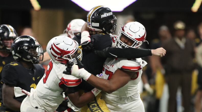 December 12, 2018 - Atlanta, Ga: Colquitt County quarterback Jaycee Harden (4) is hit hard after a pass attempt by Milton defenders Allen Walker (9, left) and Paul Tchio (57) in the fourth quarter during the Class AAAAAAA State Championship at Mercedes-Benz Stadium Wednesday, December 12, 2018, in Atlanta. Milton won 14-13. (JASON GETZ/SPECIAL TO THE AJC)