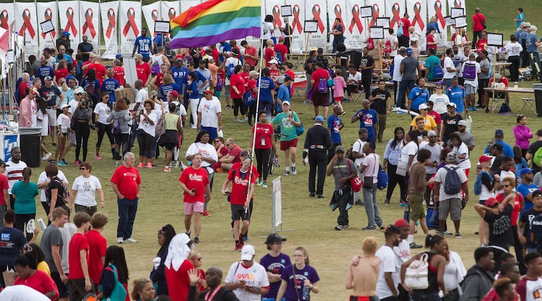 Marion Lenz walks through the crowd with a rainbow flag during the 27th Annual AIDS Walk Atlanta & 5K Run at Piedmont Park on Oct. 22, 2017.