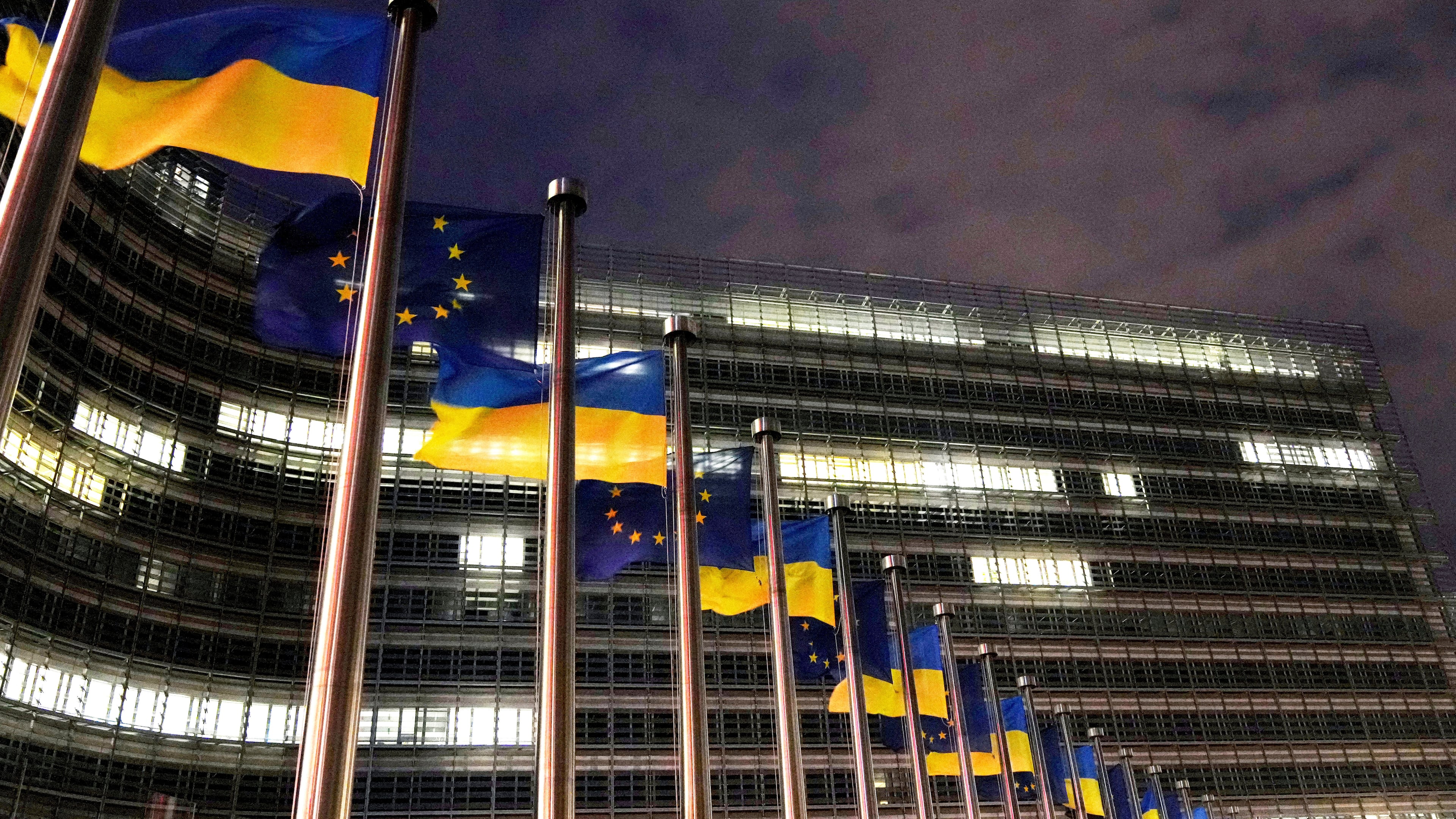 FILE - The European Union and Ukrainian flags flap in the wind to mark the third anniversary of Russia's full-scale invasion of Ukraine outside EU headquarters in Brussels, Feb. 24, 2025. (AP Photo/Virginia Mayo, File)