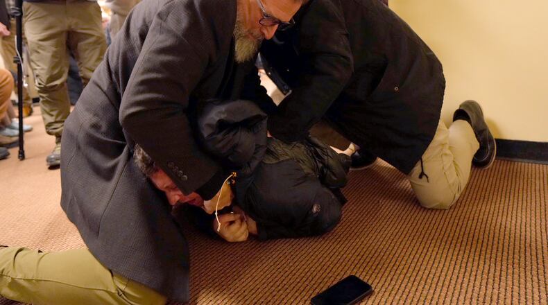 A man is tackled to the ground after spraying an unknown substance on U.S. Rep. Ilhan Omar, D-Minn., during a town hall on Tuesday, Jan. 27, 2026, in Minneapolis. (Richard Tsong-Taatarii/Star Tribune via AP)