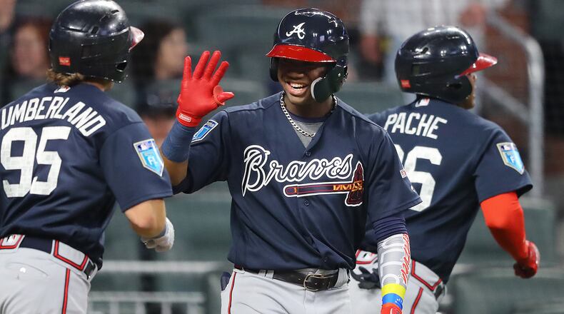 Ronald Acuna gives outfielder Cristian Pache (right) and Brett Cumberland (left) high fives at home plate after Pache hit a 2-run homer off pitcher Sean Newcomb to tie the game 2-2 during the third inning in the Future Stars Exhibition Game on Tuesday, March 27, 2018, at SunTrust Park in Atlanta. Curtis Compton/ccompton@ajc.com