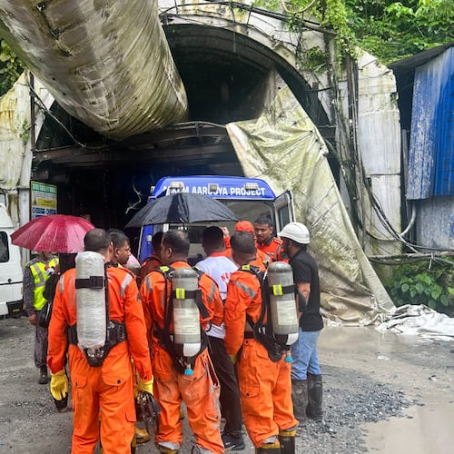 Members of the rescue team carry oxygen cylinders outside the entrance to an under-construction tunnel at a hydropower project in Samardung village, about 40 kilometers (25 miles) from Gangtok, India, Tuesday, July 21, 2026. (AP Photo)