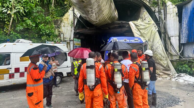 Members of the rescue team carry oxygen cylinders outside the entrance to an under-construction tunnel at a hydropower project in Samardung village, about 40 kilometers (25 miles) from Gangtok, India, Tuesday, July 21, 2026. (AP Photo)
