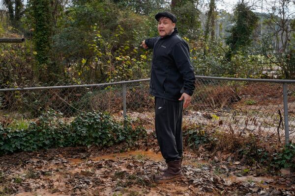 Decatur homeowner Mathew Holmes shows the damage to his yard after a water main break Monday morning. (Ben Hendren for the AJC)