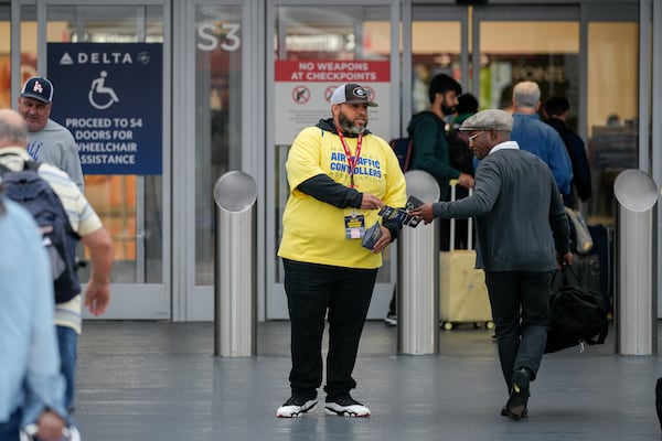 Members of the National Air Traffic Controllers Association union distributed leaflets about the shutdown’s effects at nearly two dozen airports to raise awareness, including Atlanta. One NATCA member hands out leaflets at the domestic terminal of Hartsfield-Jackson Atlanta International Airport. (Ben Hendren for the AJC)