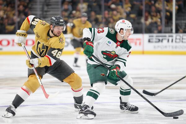 Minnesota Wild center Marco Rossi (23) skates past Vegas Golden Knights center Tomas Hertl (48) during the second period in Game 1 of an NHL hockey Stanley Cup first-round playoff series Sunday, April 20, 2025, in Las Vegas. (AP Photo/Ian Maule)