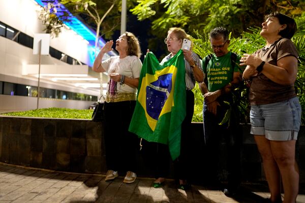 Supporters pray for the health of former Brazilian President Jair Bolsonaro after transferring to a DF Star hospital with abdominal pain in Brasilia, Brazil, Saturday, April 12, 2025. (AP Photo/Eraldo Peres)