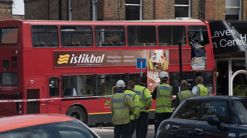 Police , firemen and emergency workers on the scene of a bus accident in southwest London on Thursday..