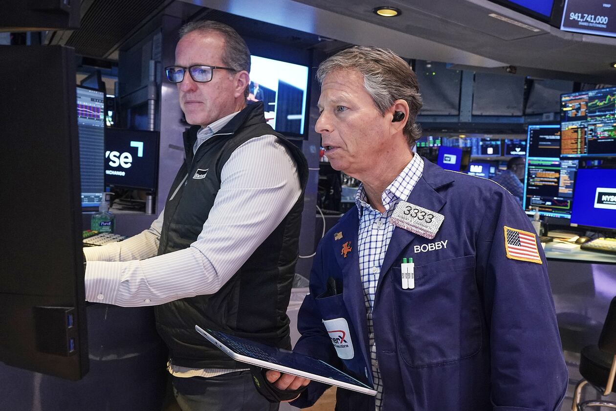 Specialist Glenn Carell, left, and trader Robert Charmak work on the floor of the New York Stock Exchange, Friday, May 22, 2026. (AP Photo/Richard Drew)