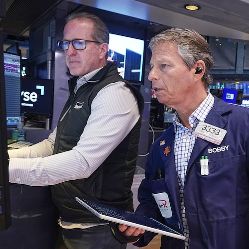 Specialist Glenn Carell, left, and trader Robert Charmak work on the floor of the New York Stock Exchange, Friday, May 22, 2026. (AP Photo/Richard Drew)