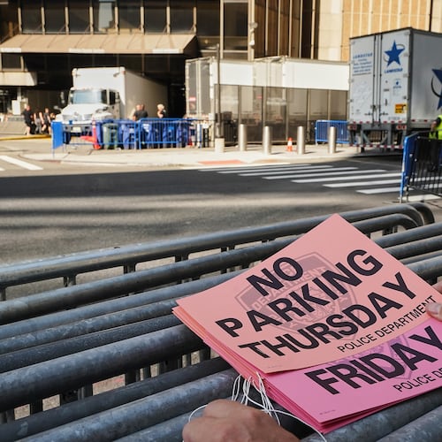 A worker holds "No Parking" signs prior to posting as trucks fill the loading dock outside New York's Madison Square Garden, Wednesday, July 1, 2026. (AP Photo/Richard Drew)