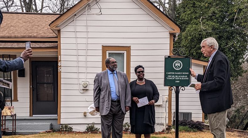 Members of the Carter family, Marcus Carter and Rev. Kennetta Carter, stand beside Marietta Mayor Steve "Thunder" Tumlin with the historic home marker for the 1909 Carter House in Marietta, Georgia, on December 7, 2022. (Photo by Cobb Landmarks)
