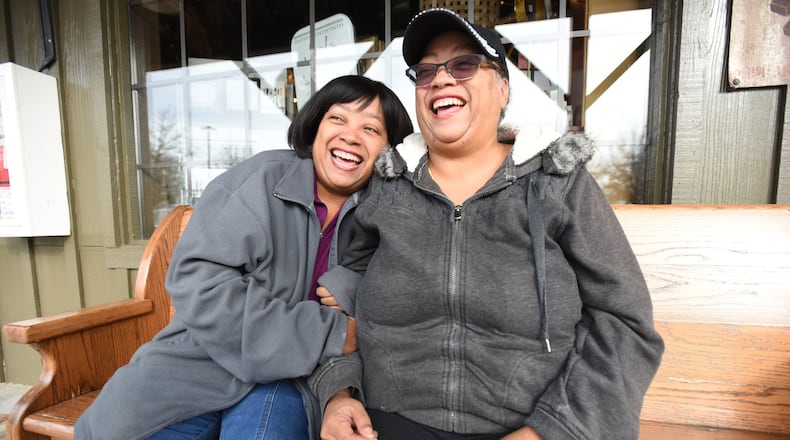 Twin sisters Priscilla (left) and Patricia Moses react as Patricia holds a gift donation from Keri Janton (not pictured), freelance writer and founder of Maximus Janton Foundation, in Norcross on Friday, January 10, 2020. The Moses sisters fostered and adopted dozens of children over the past 20 years and were featured in a December 2019 AJC story, have received a number of donations from AJC readers wanting to help the family.