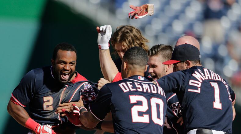 Washington Nationals batter Denard Span (L) is congratulated by teammates after his batted ball, with bases loaded, was bobbled by the Atlanta Braves shortstop Andrelton Simmons (not pictured), in Game 1 of their day-night doubleheader in the ninth inning of their MLB National League baseball game in Washington September 17, 2013. The Nationals won the game on this play.