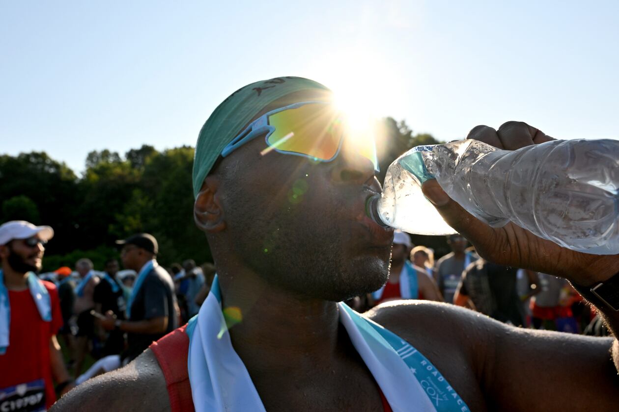 FILE: A runner cools down after crossing the finish line of the 56th running of the Atlanta Journal-Constitution Peachtree Road Race in Atlanta on Friday, July 4, 2025. (Hyosub Shin / AJC)
