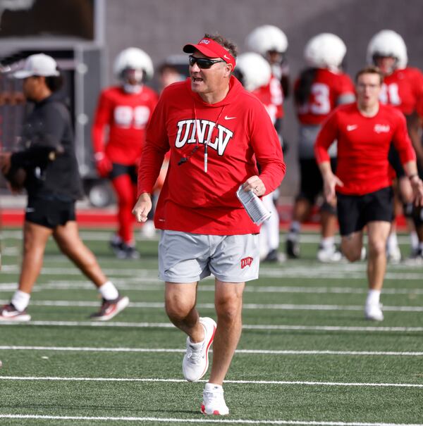 UNLV football head coach Dan Mullen leads his team onto to the field for a team practice in Las Vegas, Thursday, March 27, 2025. (Bizuayehu Tesfaye/Las Vegas Review-Journal via AP)