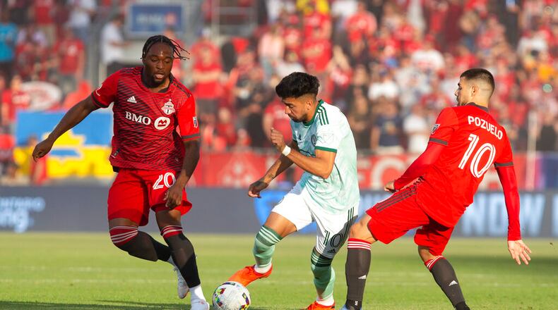 Atlanta United midfielder Marcelino Moreno, center, takes the ball between Toronto FC forward Ayo Akinola and midfielder Alejandro Pozuelo, right, during the first half of an MLS soccer match Saturday, June 25, 2022, in Toronto. (Chris Young/The Canadian Press via AP)