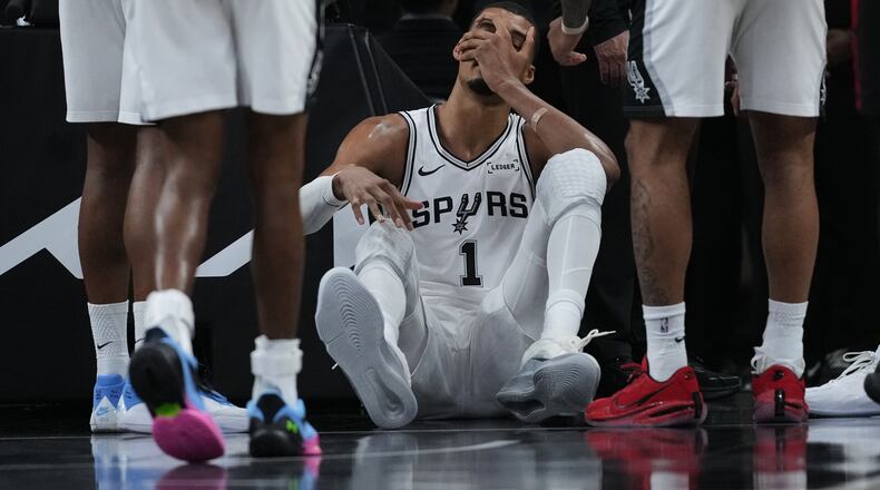 San Antonio Spurs forward Victor Wembanyama (1) sits on the court after a hard fall during the first half in Game 2 of a first-round NBA playoffs basketball series against the Portland Trail Blazers in San Antonio, Tuesday, April 21, 2026. (AP Photo/Eric Gay)