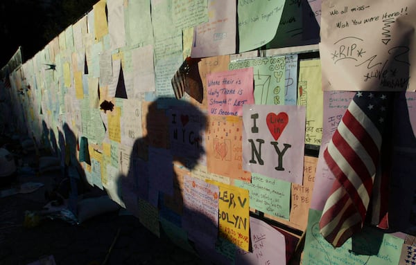 FILE - Late evening shadows are cast across messages left by visitors on a wall standing in Union Square Park Wednesday, Sept. 11, 2002, in New York, to mark the one year anniversary of the Sept. 11 terrorist attacks. (AP Photo/Beth A. Keiser, File)