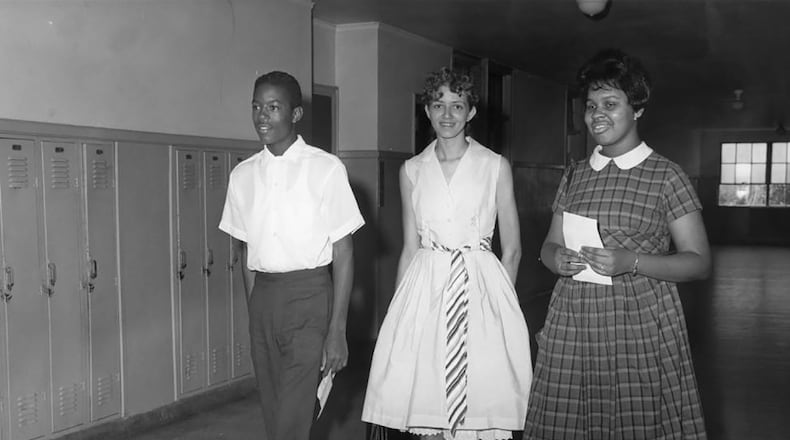 The three students selected to integrate Brown High School walk down the hall, possibly on registration day, one day before the school integrated: Thomas Welch, who entered Brown as a junior, would eventually go on to get a master's in city planning from MIT and would become a real estate developer in Boston. Damaris Allen, center, chose to take an early admission to Spelman at age 16 and wound up never attending Brown. Madelyn Nix, right, became a corporate attorney in Pennsylvania. Welch and Nix were on hand in 2011 for an APS ceremony honoring the Atlanta Nine. (Bill Wilson / AJC Archive at the GSU Library AJCP297-004a)