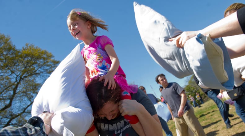 Leela Bagby (top) spins on her mother Cheryl's shoulders as she is attacked with pillows at the 2013 Atlanta event.
