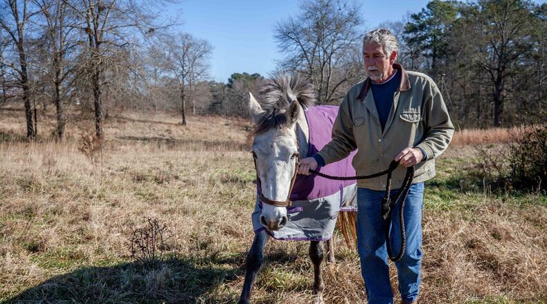 Frans Insinger of Rockdale County, shown here with Raine at the horse farm where he and his wife board horses, stays relatively healthy. But health insurance premiums on the Affordable Care Act’s exchange for Insinger and his wife have skyrocketed anyway. They make too much to qualify for subsidies, and this year they found that if they lived in the same ZIP code but over the county line, their premium would be $200 less. (PHOTO by BRANDEN CAMP/ special to the AJC)