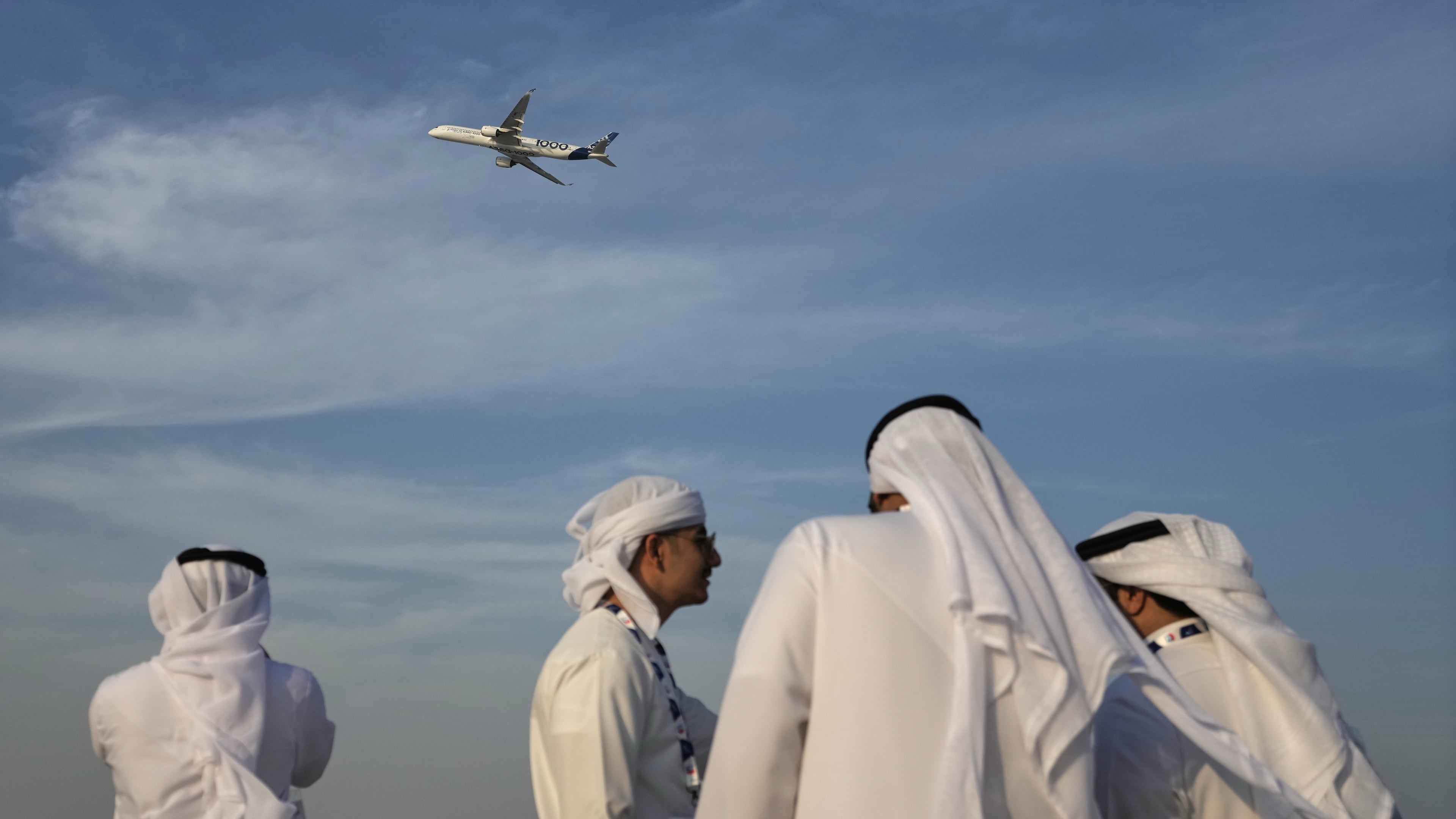 Emirati men watch an Airbus A350 at the Dubai Air Show in Dubai, United Arab Emirates, Monday, Nov. 17, 2025. (AP Photo/Fatima Shbair)