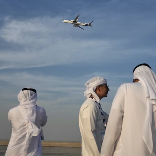 Emirati men watch an Airbus A350 at the Dubai Air Show in Dubai, United Arab Emirates, Monday, Nov. 17, 2025. (AP Photo/Fatima Shbair)