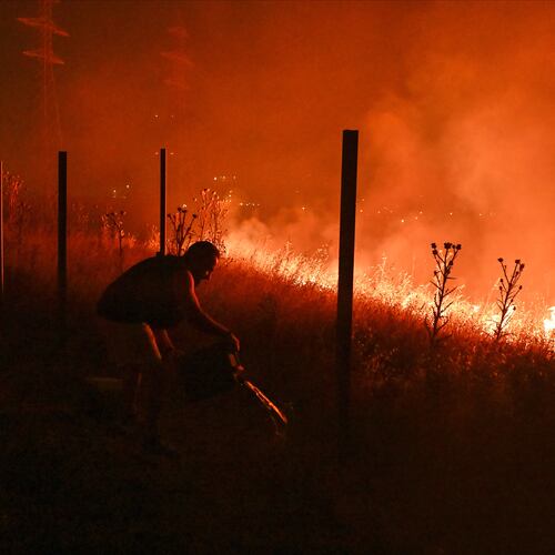 Locals try to extinguish a wildfire on the outskirts of the northern city of Thessaloniki, Greece, Saturday, July 4, 2026. (AP Photo/Giannis Papanikos)