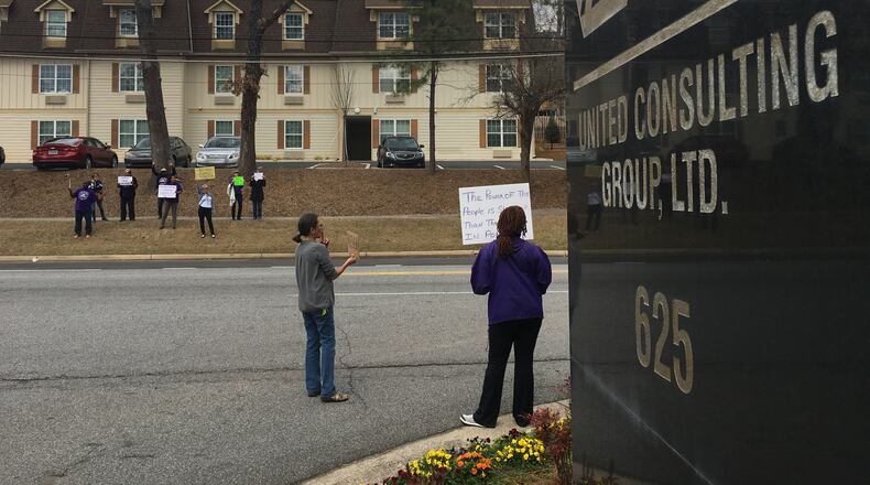 A handful of protesters showed up Monday afternoon outside the Norcross offices of United Consulting, which employs embattled Gwinnett County Commissioner Tommy Hunter.