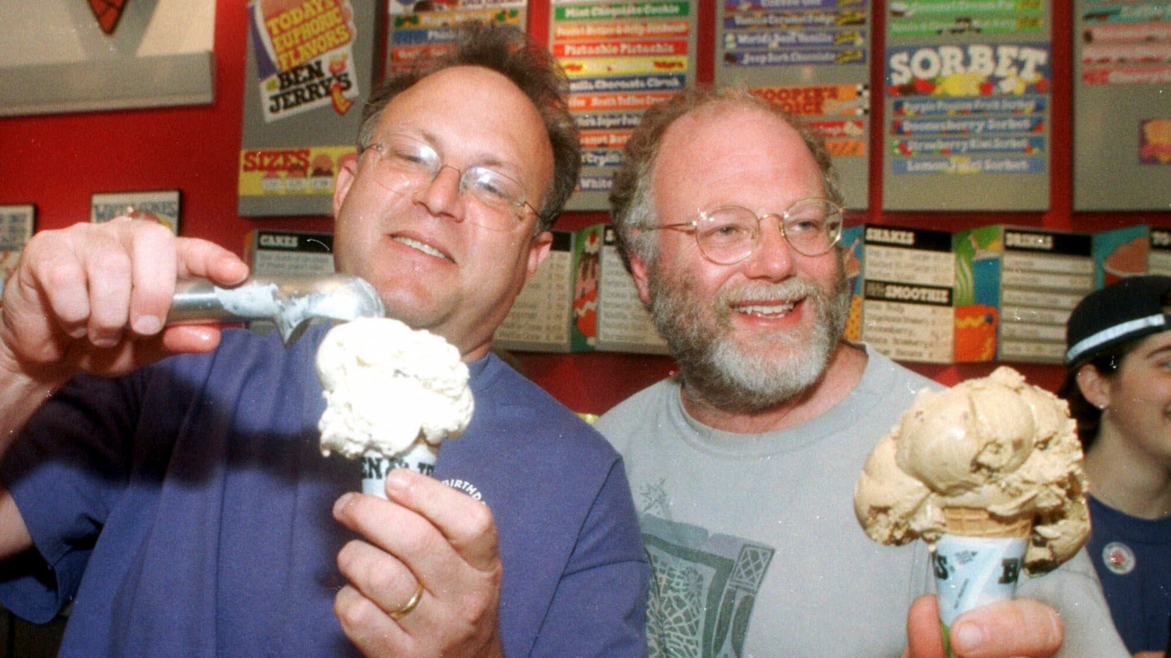 FILE - Jerry Greenfield, left, and Ben Cohen scoop ice cream cones during their 20th anniversary party at a scoop shop in Burlington, Vt., in this May 5, 1998 photo. (AP Photo/Toby Talbot, File)