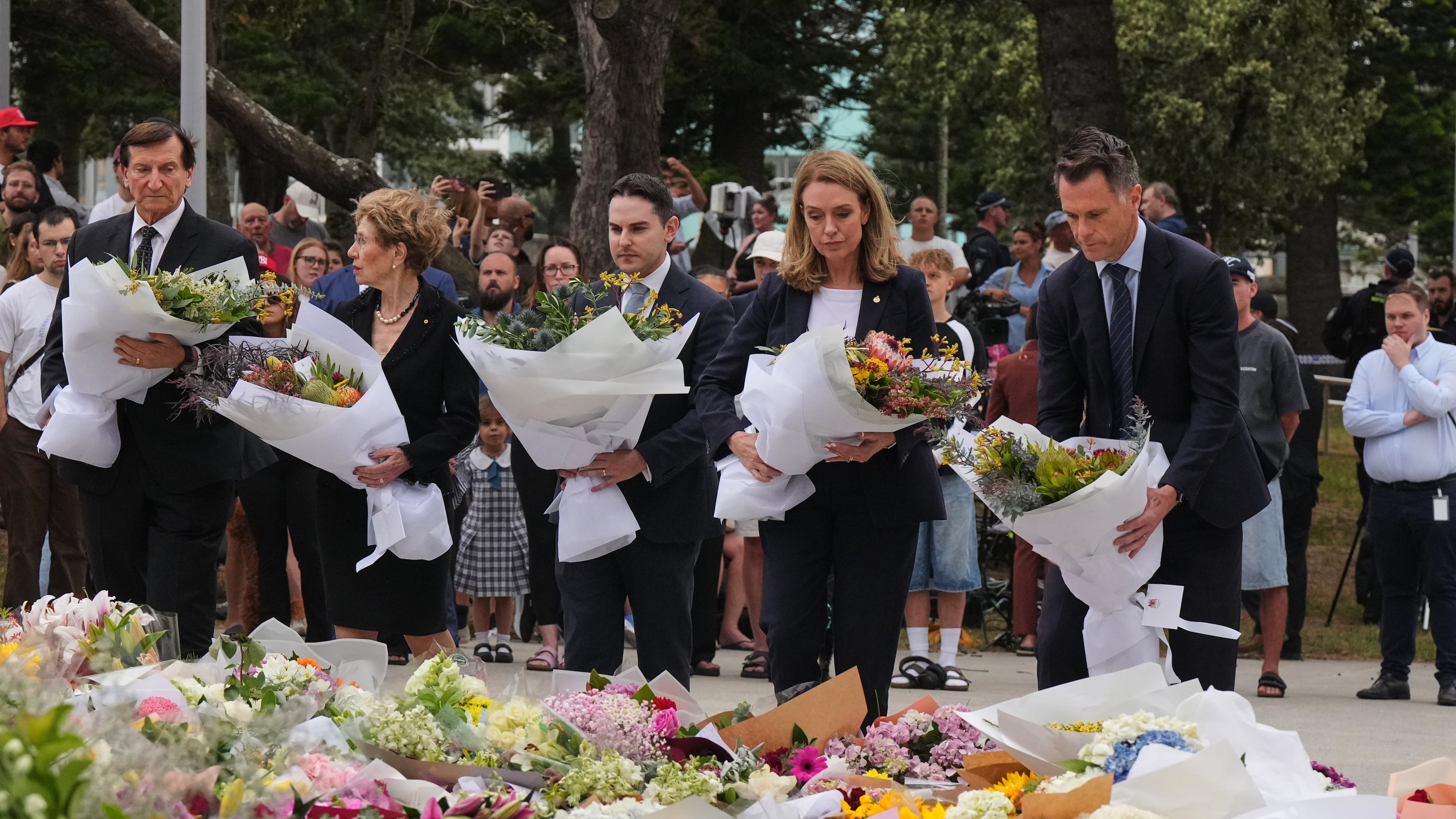 New South Wales Premier Chris Minns, right, and Kellie Sloane, leader of the opposition, the New South Wales Liberal Party, lay wreaths at a tribute for shooting victims outside the Bondi Pavilion at Sydney's Bondi Beach, Monday, Dec. 15, 2025, a day after a shooting. (AP Photo/Mark Baker)