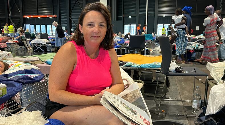 Morgane Bonichot, 40, takes a break from reading a newspaper in an evacuation center in Bordeaux, on Tuesday, July 28, 2026, where she, her daughter, their rabbit and dog are sheltering from wildfires in southwest France. (AP Photo/Eva van Dam)