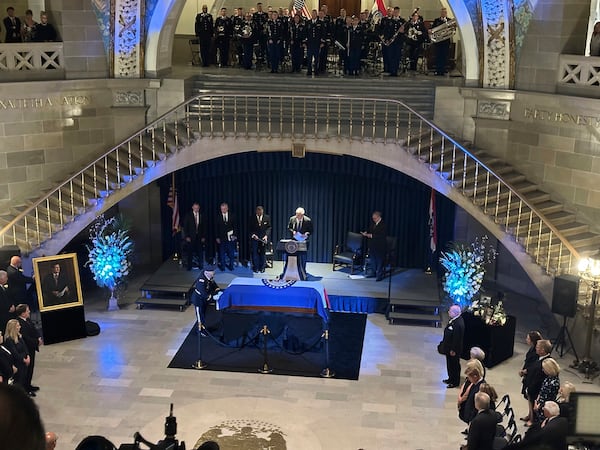 An officer stands by the casket of former Missouri Gov. and U.S. Sen. Christopher "Kit" Bond as former U.S. Sen. John Danforth prepares to speak at a memorial service for Bond on Tuesday, May 20, 2025, in the Missouri Capitol in Jefferson City, Mo. (AP Photo/David A. Lieb)