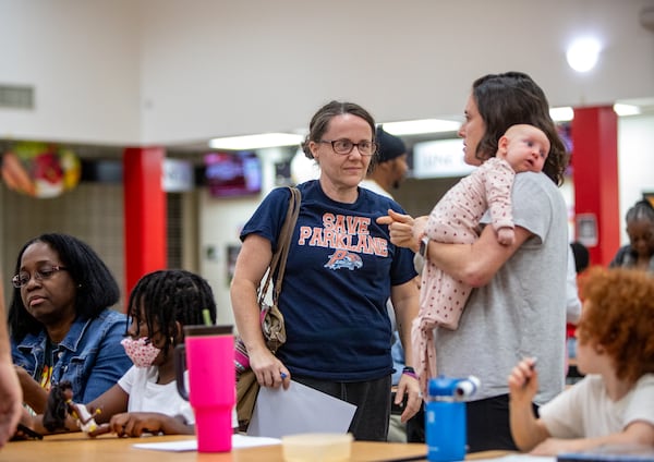 Concerned South Fulton elementary school parents, including Christy Taylor, center, talk with other Parklane Elementary School parents at Tri-Cities High School on Wednesday, Nov 6, 2024. (Jenni Girtman for The AJC)