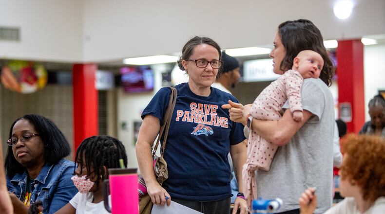 Concerned South Fulton elementary school parents, including Christy Taylor, center, talk with other Parklane Elementary School parents at Tri-Cities High School on Wednesday, Nov 6, 2024 after formal remarks from Fulton County Schools. (Jenni Girtman for The Atlanta Journal-Constitution)